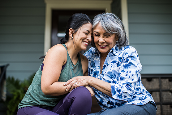 Mother and daughter hugging while smiling.